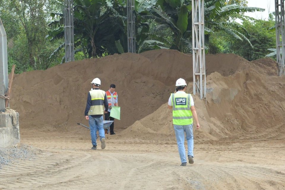 Profissionais de capacete e colete realizando vistoria em instalação industrial